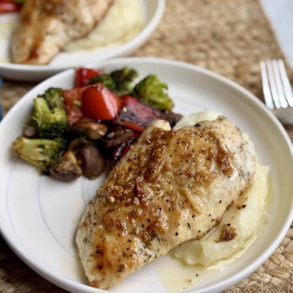 Garlic butter chicken on a plate and vegetables. 