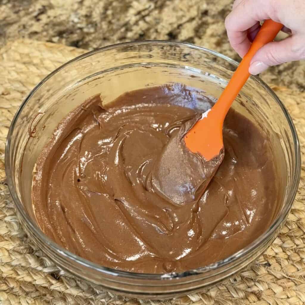 Mixing chocolate and whipped cream in a bowl.