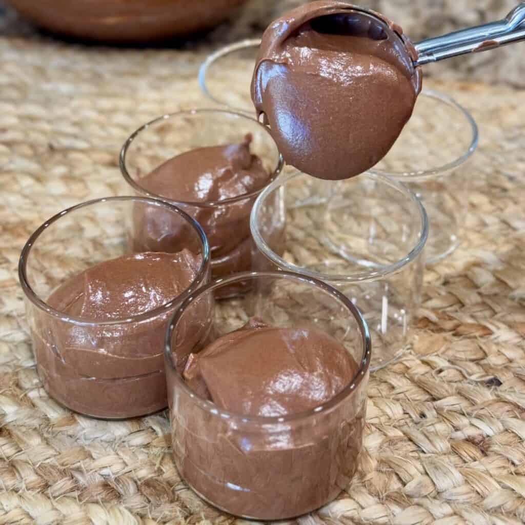 Filling ramekins with 3 ingredient chocolate mousse.