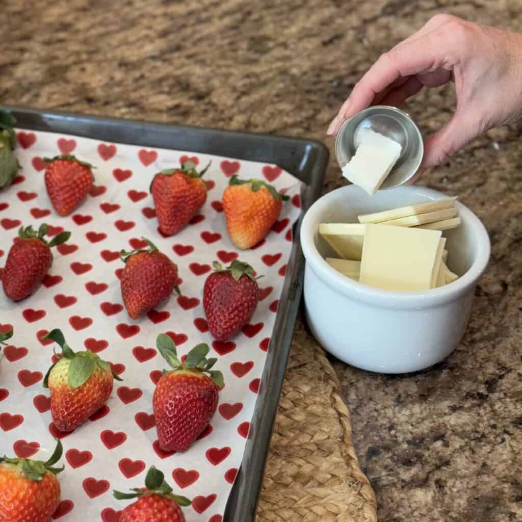 Mixing together white chocolate and shortening in a bowl.