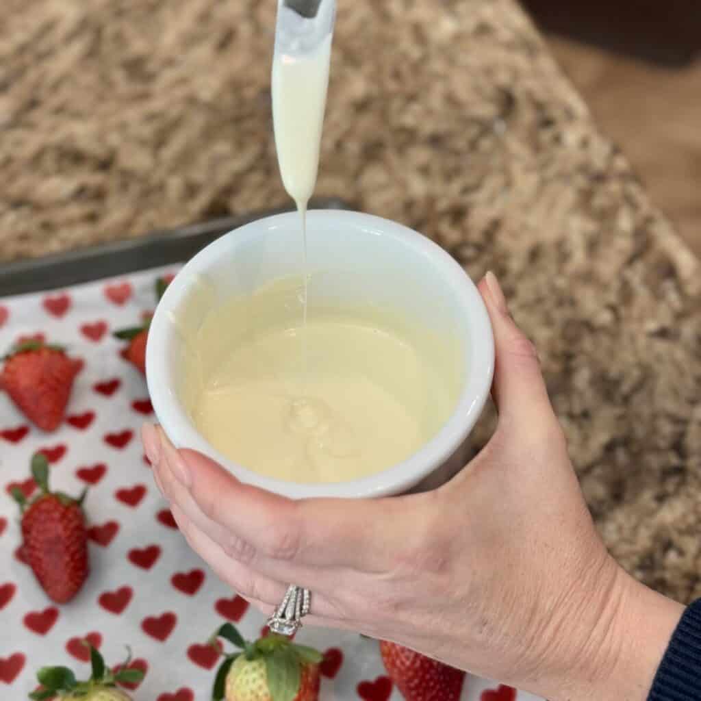 Mixing together white chocolate and shortening in a bowl.