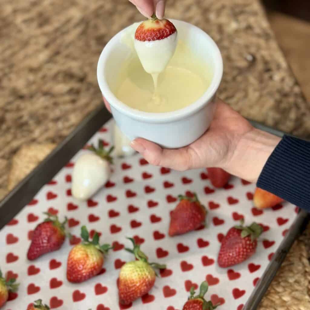 Dipping strawberries in white chocolate.