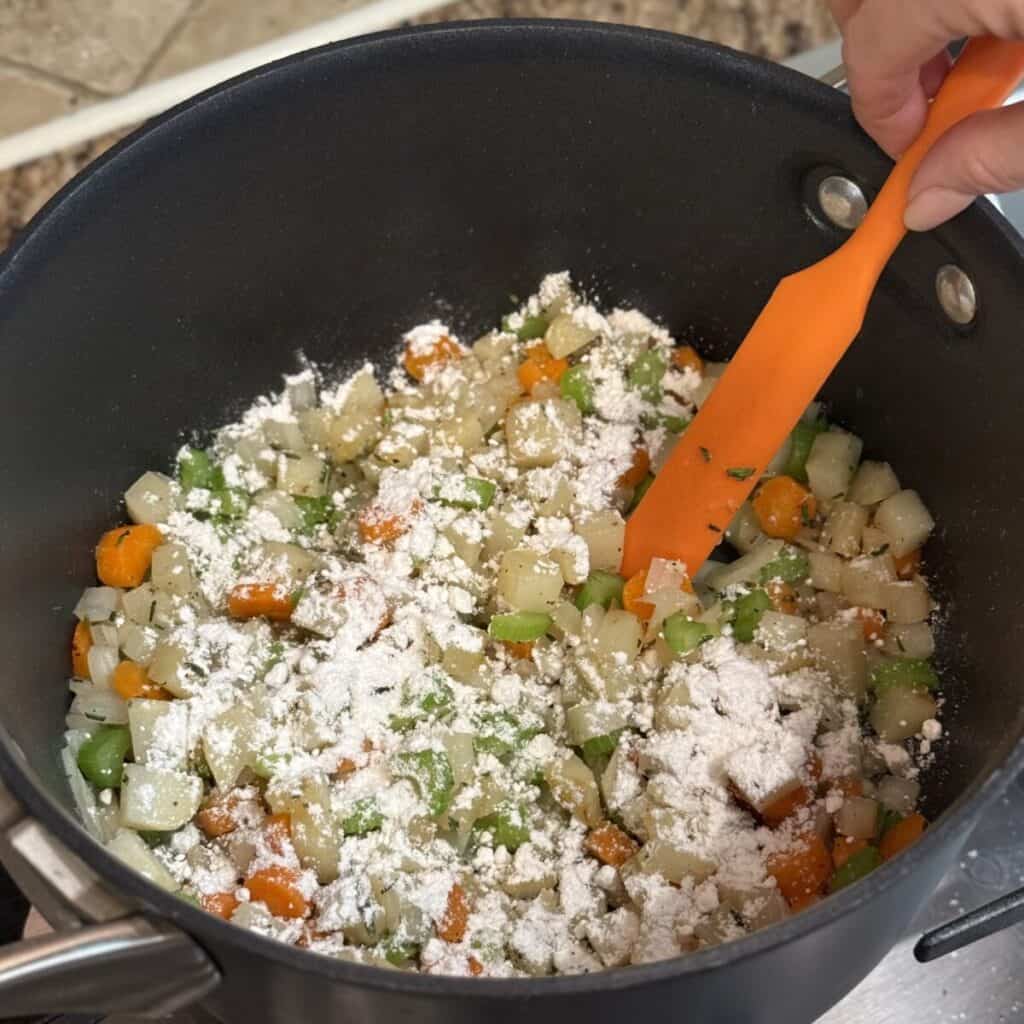 Cooking vegetables and flour in a stockpot.