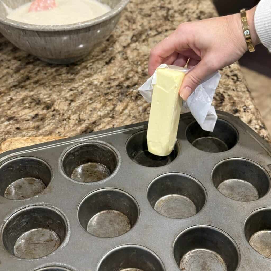 Buttering a muffin pan.