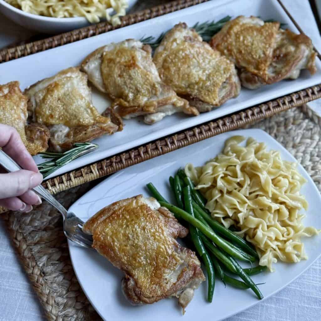 A plate of chicken, noodles and green beans.