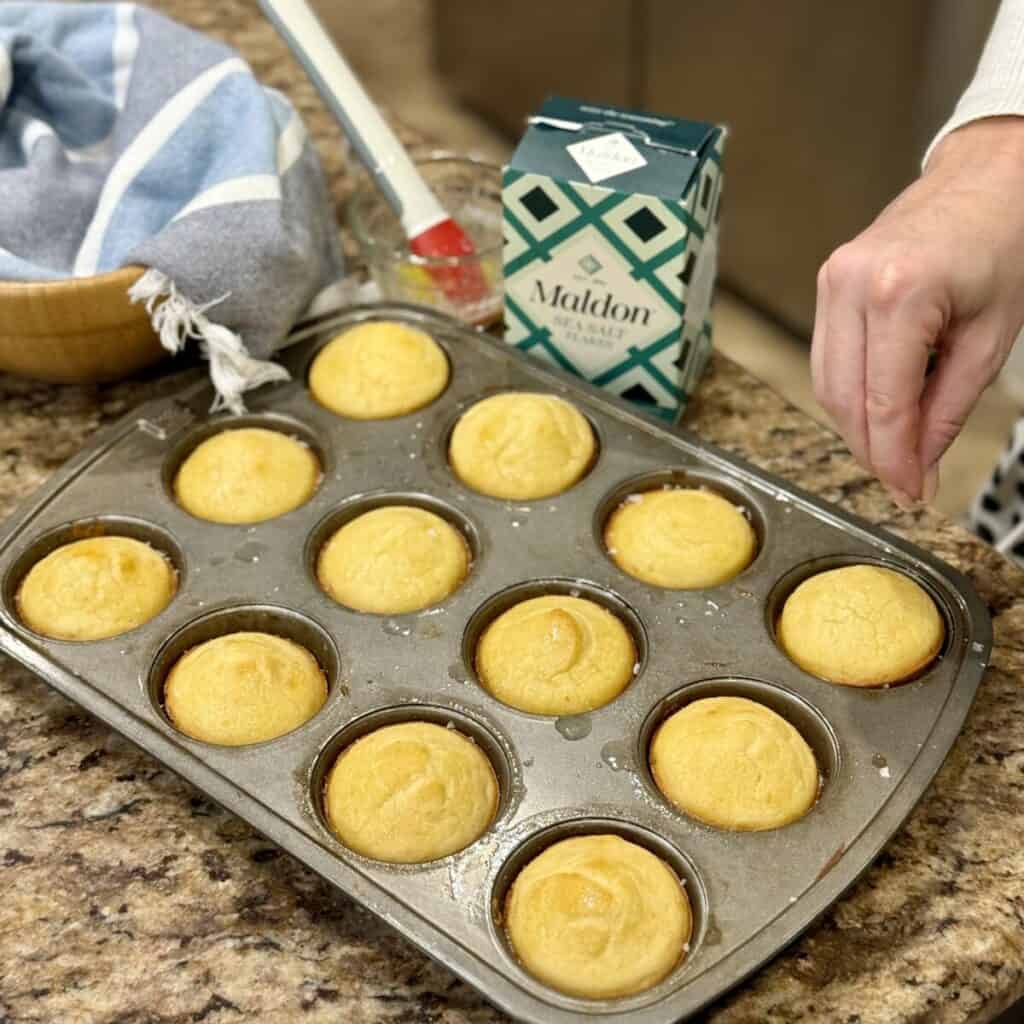 Sprinkling salt on top of rolls.